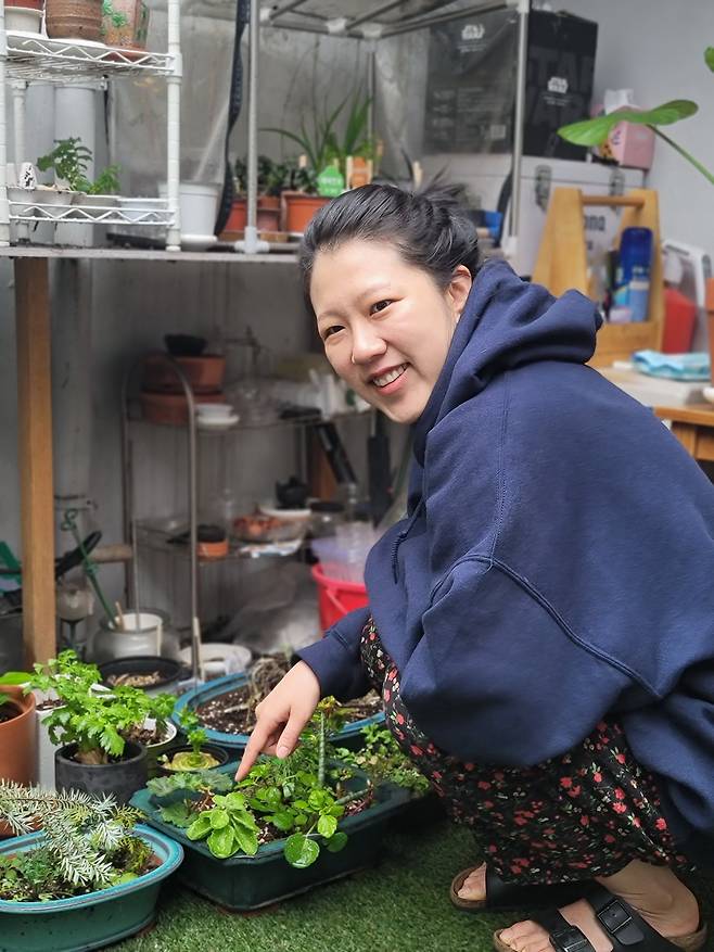 마당에 있는 식물을 돌보고 있는 백수혜 작가