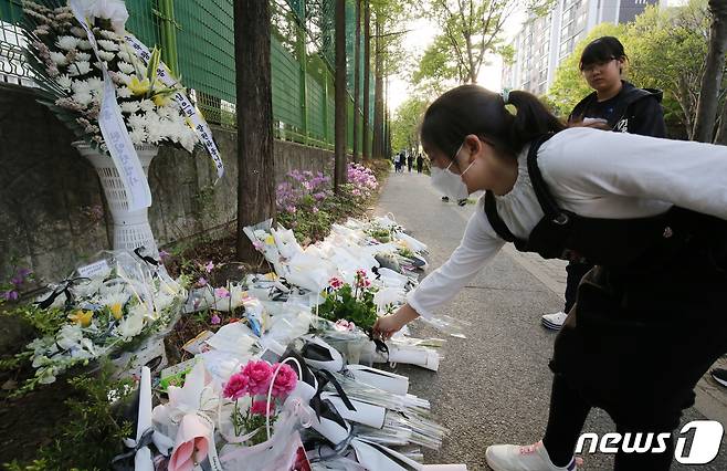 지난 8일 오후 2시 21분께 대전 서구 둔산동에서 60대 음주운전자의 차량에 숨진 배승아양을 추모하기 위해 한 소녀가 사고 현장에 국화꽃을 놓고 있다. ⓒNews1 김기태 기자