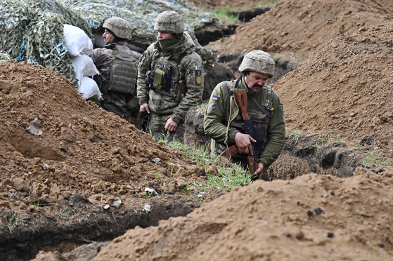 Ukrainian servicemen stand in a trench near their position near the town of Bakhmut, Donetsk region in Ukraine on Saturday, amid the Russian invasion of Ukraine. [AFP/YONHAP]