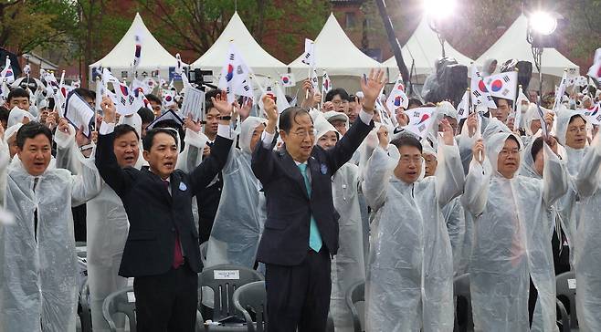 한덕수 국무총리(왼쪽 셋째)와 박민식 국가보훈처장(둘째) 등이 11일 서울 서대문구 독립공원에서 비가 내리는 가운데 열린 제104주년 대한민국 임시정부 수립 기념식에 참석해 태극기를 흔들고 있다.  이충우 기자