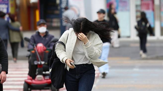 도로에서 행인들이 바람을 맞으며 횡단보도를 건너고 있다. 연합뉴스