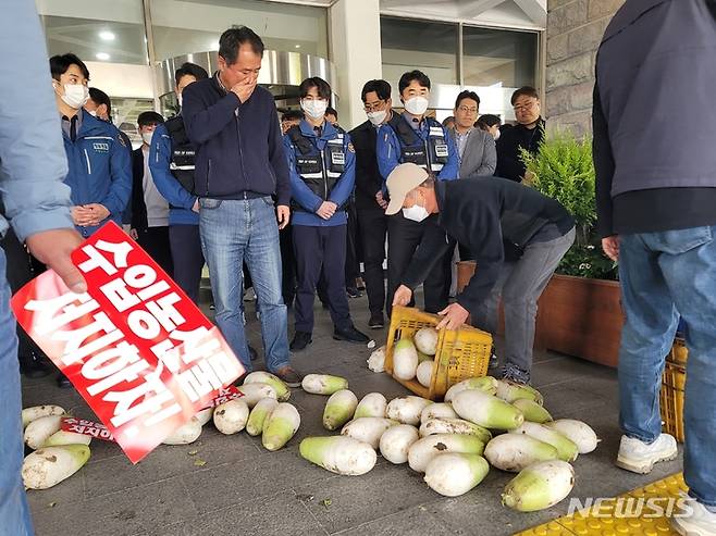 [제주=뉴시스] 오영재 기자 = 전국농민회총연맹 제주도연맹이 12일 오전 제주도청 앞에서 정부의 무관세 무 수입 결정에 반발하며 무를 버리고 있다. 2023.04.12. oyj4343@newsis.com