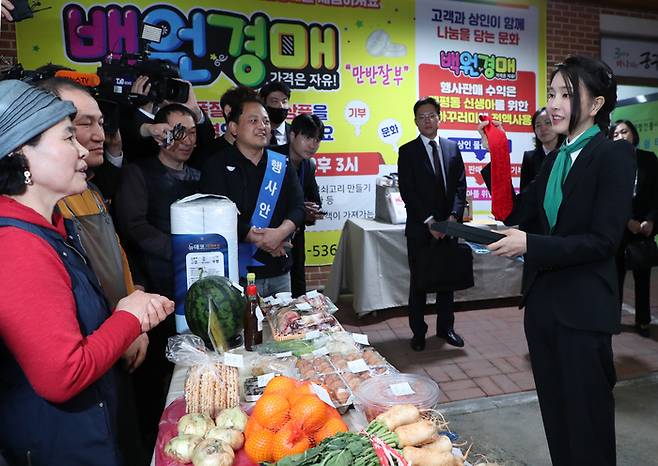 김건희 여사가 14일 대전 중구 태평전통시장을 방문, 백원경매 행사장에서 윤석열 대통령이 직접 맸던 넥타이를 기부하고 있다. 경매는 백원으로 시작하며 발생한 수익금으로 육아꾸러미를 제작해 태평동에 출생신고한 신생아들에게 기부된다. [대통령실통신사진기자단]