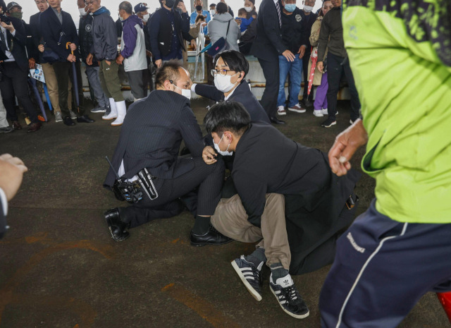 15일 오전 11시 30분께 기시다 후미오 일본 총리가 일본 와카야마(和歌山)현에서 현장 시찰을 마치고 연설을 시작하기 직전 폭발음을 야기시킨 물체를 던진 남성이 체포되고 있다. 교도연합뉴스