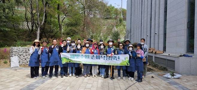 수원 새빛수원 손바닥정원단이 수원시연화장에 손바닥 정원을 조성한 뒤 기념사진을 찍고 있다.