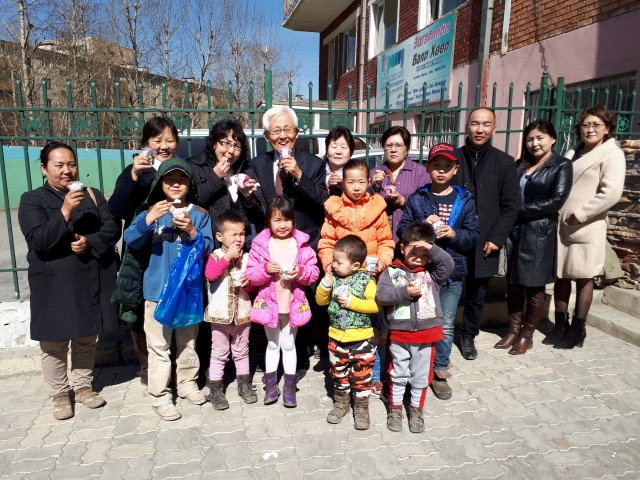 한겨울 예배당 입구에서 어린이와 아이스크림을 맛있게 먹고 있다. 뒷줄 인쪽 네번째가 필자.