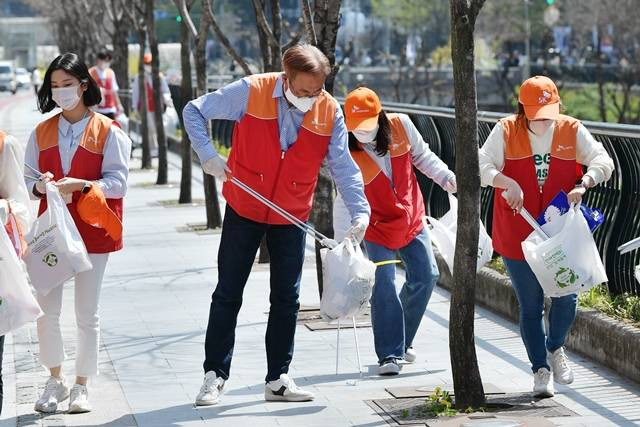 SK이노베이션이 '지구의 날'을 맞아 오는 21일까지 국내외 모든 사업장 구성원이 참여하는 친환경 플로깅 '산해진미 위크'를 시행한다. 사진은 지난해 4월 김준 SK이노베이션 부회장(왼쪽에서 두 번째)과 신입사원들이 서울 종로구 일대에서 '산해진미' 활동을 펼치는 모습. /SK이노베이션