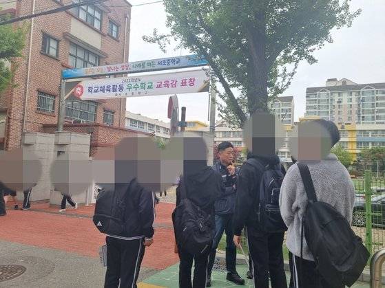 서울 서초구 서초중학교에서 서초경찰서 학교전담경찰관 박진호 팀장이 학생들과 이야기를 나누고 있다. 서초경찰서 학교전담경찰팀은 종종 등하굣길에 통학 지도를 하며 아이들과 소통한다. 박 팀장은 "아이들이 경찰들 말을 담임선생님 말씀이나 부모님 말씀보다 더 무겁게 여기기 때문에 통학 지도가 효과가 있다"고 말했다. 신혜연 기자