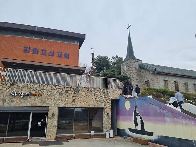 강화 교산교회에는 선상 세례 장면을 묘사한 벽화가 그려져 있다. 계단 위 오른쪽 건물은 '강화 초대 기독교선교역사관'. /김한수 기자