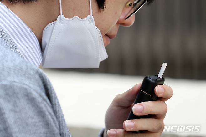 [서울=뉴시스] 백동현 기자 = 서울 시내 한 흡연장에서 시민이 마스크를 벗고 담배를 태우고 있다. 2022.04.12. livertrent@newsis.com