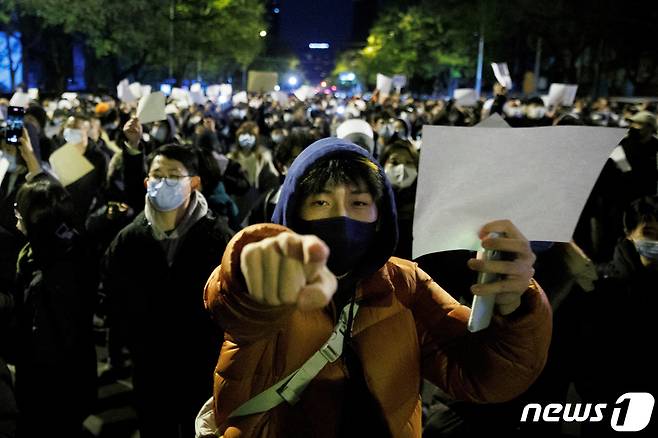 중국 베이징에서 우루무치에서 발생한 화재 희생자를 위한 철야 시위가 끝난 뒤에도 시민들이 당국의 제로 코로나 정책에 항의하기 의미로 백지를 들고 있다. 2022.11.27 ⓒ 로이터=뉴스1 ⓒ News1 권진영 기자