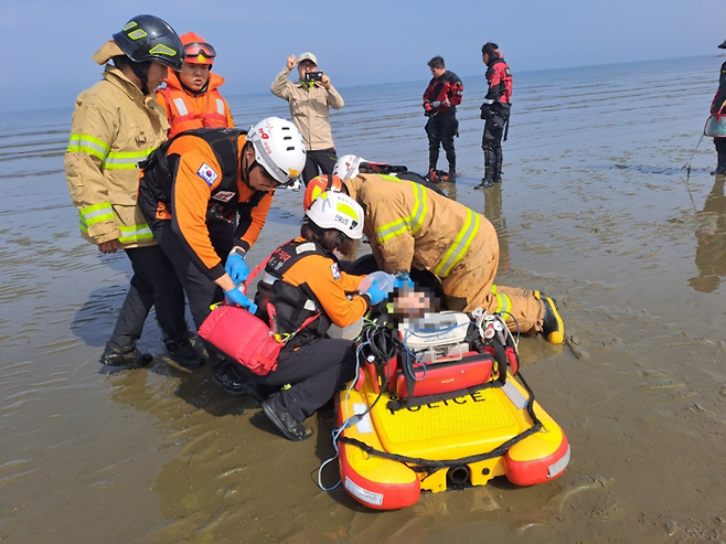 20일 오전 9시 9분쯤 전북 부안군 고사포해수욕장 인근에서 스킨스쿠버 다이빙을 하던 4명이 바다에 빠지는 사고가 발생했다. 신고를 받고 출동한 소방대원이 구조자를 응급처치하고 있다. 전북소방본부 제공