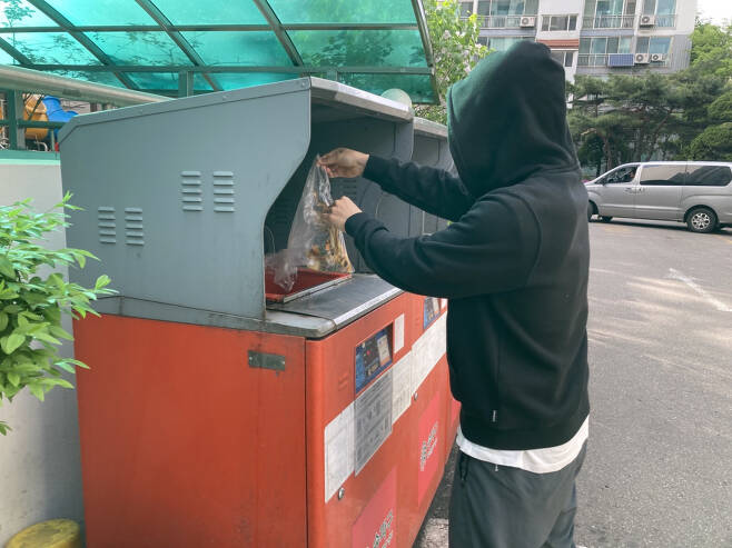 한 남성이 음식물 쓰레기를 버리고 있다[독자 제공]
