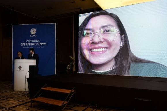 태국대표팀 세터 폰푼 게드파르드가 21일 비대면으로 열린  V리그 여자부 아시아쿼터 드래프트에서 1순위로 IBK기업은행에 지명된 뒤 대형 스크린 속에서 활짝 웃고 있다.  [한국배구연맹 제공]