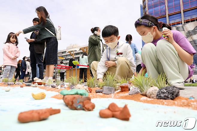 22일 서울 종로구 광화문광장에서 지구의 날을 맞아 열린 '2023 지구의 날 행사'를 찾은 어린이들이 분필로 바닥에 환경보호 메시지를 적고 있다. 2023.4.22/뉴스1 ⓒ News1 민경석 기자