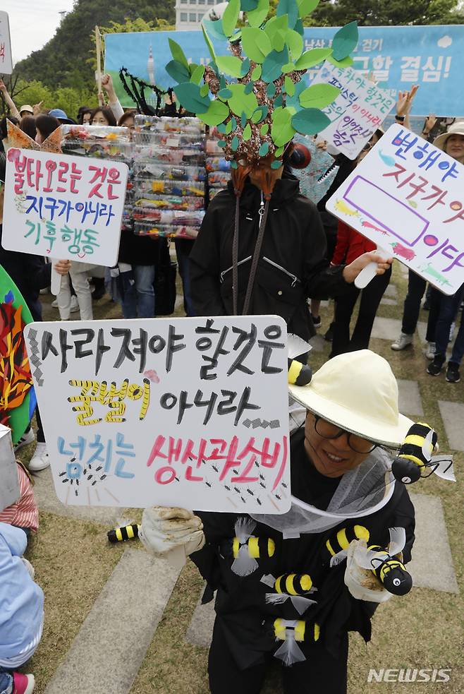 [서울=뉴시스] 고승민 기자 = 환경단체 소비자기후행동과 시민들이 22일 서울 남산공원 백범광장에서 지구의 날을 맞아 남산 둘레길 걷기 캠페인을 하기 전 포즈를 취하고 있다. 2023.04.22. kkssmm99@newsis.com