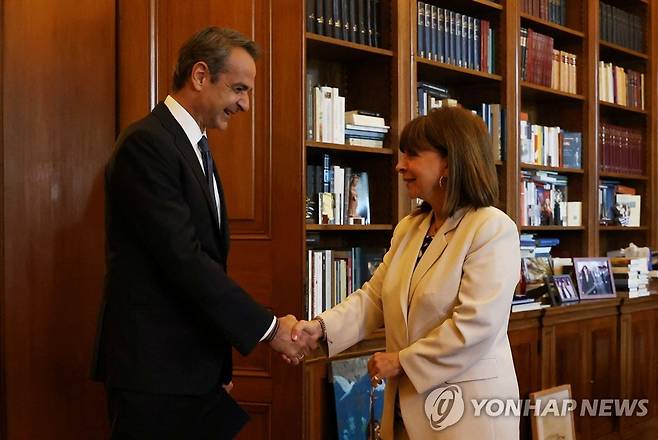 악수하는 미초타키스 총리와 사켈라로풀루 대통령 (아테네 로이터=연합뉴스) 그리스의 키리아코스 미초타키스 총리(왼쪽)가 22일(현지시간) 아테에에 있는 대통령궁에서 카테리나 사켈라로풀루 대통령과 만나 악수하고 있다. 2023.04.22 photo@yna.co.kr