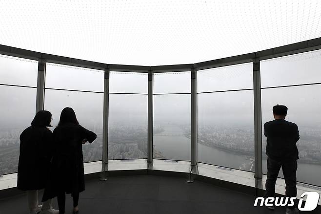 절기상 곡우(穀雨)인 4월20일 오후 서울 송파구 롯데월드타워 전망대 '서울스카이'를 찾은 시민들이 구름 낀 한강 일대를 보고 있다. 2023.4.20/뉴스1 ⓒ News1 구윤성 기자