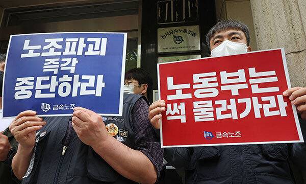 지난 21일 금속노동조합 관계자들이 고용노동부의 회계서류 비치·보존 여부 관련 노조 대상 현장 조사를 앞두고 서울 중구 금속노조 사무실 앞에서 현장 조사 규탄 팻말을 들고 있다. 연합뉴스