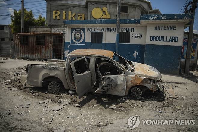 지난 20일(현지시간) 아이티 포르토프랭스에서 불에 탄 채 도로에 방치된 경찰차 [AP 연합뉴스 자료사진. 재판매 및 DB 금지]