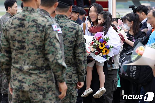 수단 군벌 간 무력 충돌로 대피한 우리 교민들이 25일 경기 성남시 서울공항에 도착해 공군 수송기 KC-330에서 내려 군 관계자들의 환영을 받고 있다. 2023.4.25/뉴스1 ⓒ News1 사진공동취재단