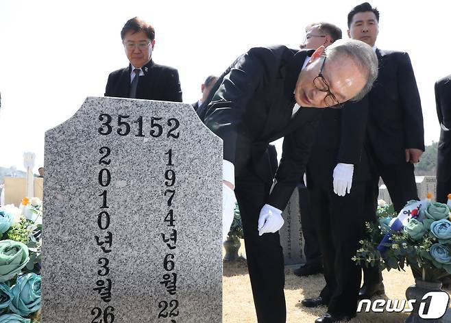 이명박 전 대통령이 서해수호의 날을 앞두고 22일 대전 유성구 국립대전현충원을 찾아 천안함 46용사 묘역에 참배한 뒤 묘비를 어루만지고 있다.. 2023.3.22/뉴스1 ⓒ News1 김기태 기자