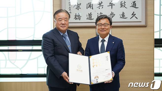 27일 오전 전호환 동명대 총장(오른 쪽)이 태권도 명예 5단 단증을 받고 기념촬영을 하고 있다(동명대 제공)