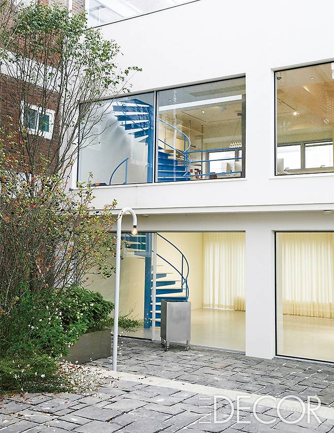 전시를 마친 뒤 하얗게 비어 있는 아파트먼트풀의 쇼룸. 층과 층을 잇는 하늘색 유선형 계단은 이곳의 큰 축이다.