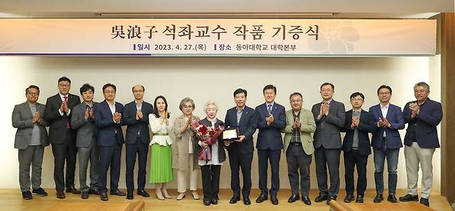 오낭자 석좌교수(왼쪽 여덟번째)와 이해우 동아대 총장(왼쪽 아홉번째), 동아대 본부위원들이 27일 동아대 승학캠퍼스 대회의실에서 작품 기증 기념촬영을 하고 있다. 사진=동아대학교 제공