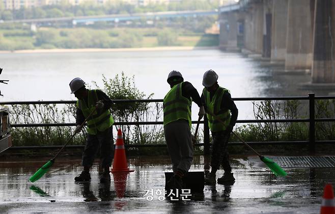 서울시 한강사업본부 관계자들이 27일 서울 성동구 한강공원 옥수나들목에서 진행된 풍수해 대비 모의훈련에서 한강 범람으로 인해 펄이 가득찬 상황을 가정해 모의 청소를 하고 있다.