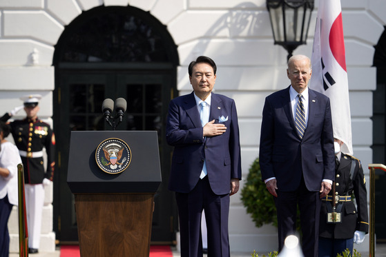 Korean President Yoon Suk Yeol, left, and U.S. President Joe Biden stand for their countries' national anthems during an arrival ceremony on the South Lawn of the White House in Washington Wednesday ahead of their bilateral summit. [AP/YONHAP]