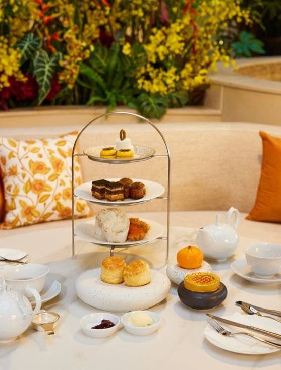 제주 불가리 카페에서 선보이는 애프터눈 티세트. 뒤로 보이는 살굿빛 패턴이 새겨진 쿠션과 화사한 화단은 리조트 컬렉션 '선셋 인 에덴'의 컨셉을 그대로 따온 것이다. 사진 불가리, 파르나스 호텔 제주