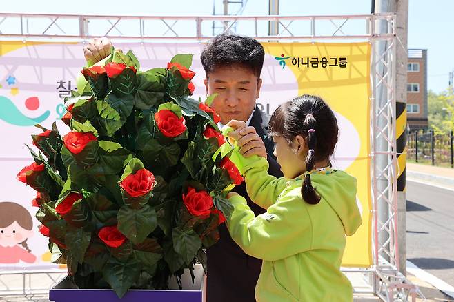 하나금융그룹은 저출산 문제 극복 및 지역사회와의 상생금융 등 사회적 책임 실천을 위해 추진 중인 '100호 어린이집 건립 프로젝트'의 일환으로 지난 28일 경북 칠곡군에 위치한 ‘국공립 칠곡 왜관하나어린이집’에서 개원식을 가졌다. 함영주 하나금융그룹 회장(왼쪽)과 칠곡 왜관하나어린이집의 원아가 화분에 물을 주고 있다./하나금융그룹 제공