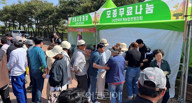 한평군 한농연 회원들이 함평나비대축제를 찾은 관람객에게 모종을 나눠주고 있다.