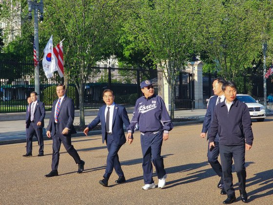 미국을 국빈 방문한 윤석열 대통령이 25일(현지시간) 워싱턴DC 백악관 인근에서 바이든 대통령이 지난해 방한 당시 선물한 모자와 선글라스, 대한민국 국가대표 야구팀 점퍼와 시구 때 신었던 국산 브랜드의 운동화를 신고 산책하고 있다. 사진 대통령실