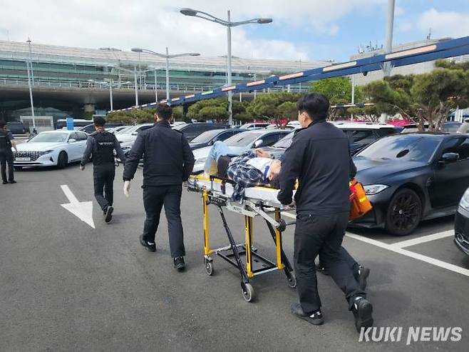 인천공항에서 환자가 발생해 보안 경비원들이 소방대원과 함께 환자를 이송하는 모습. 사진=제보자 제공