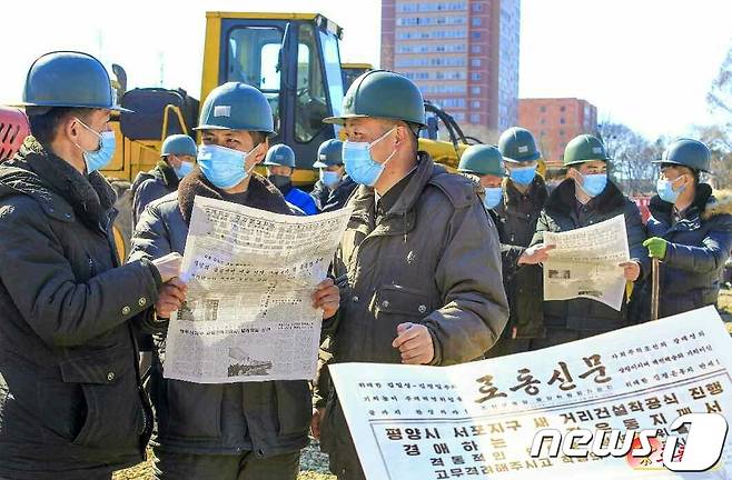 (평양 노동신문=뉴스1) = 북한 노동당 기관지 노동신문을 보고 있는 북한 주민들. [국내에서만 사용가능. 재배포 금지. DB 금지. For Use Only in the Republic of Korea. Redistribution Prohibited] rodongphoto@news1.kr