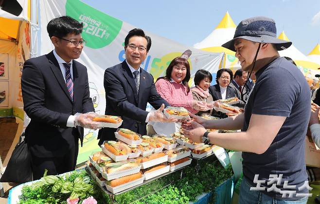 정황근 농림축산식품부 장관과 김만섭 오리자조금관리위원장, 개그우먼 김민경을 비롯한 참석자들이 1일 서울 서초구 반포한강공원에서 열린 2023 오리데이 페스티벌에서 오리고기로 만든 핫도그를 시민들에게 나눠주고 있다. 박종민 기자