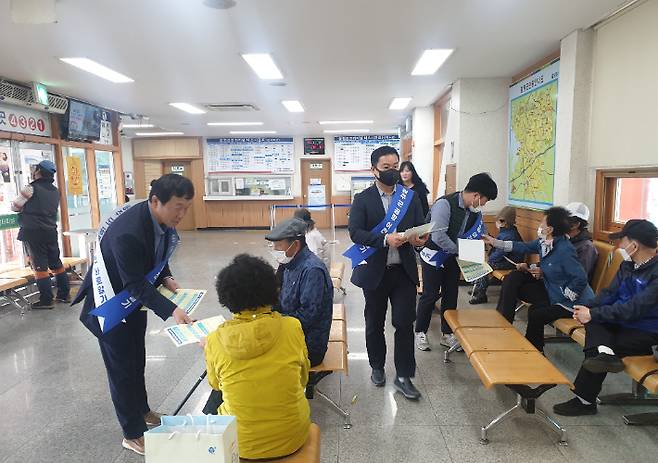 전남도 도로교통과 소속 공무원들이 3일 함평버스터미널에서 '군공항 이전 바로알기 캠페인'을 벌이고 있다. 전라남도 제공