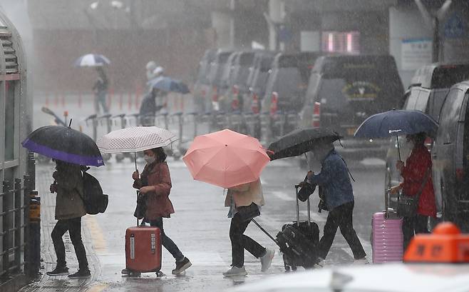 어린이날 황금연휴를 앞둔 4일 오전 제주국제공항 1층 도착장에 우산을 쓴 관광객들이 발걸음을 재촉하고 있다. 기상청에 따르면 오는 6일 오전까지 제주를 포함한 전국 대부분 지역에 강한 바람을 동반한 많은 비가 내릴 것으로 전망된다. /뉴시스