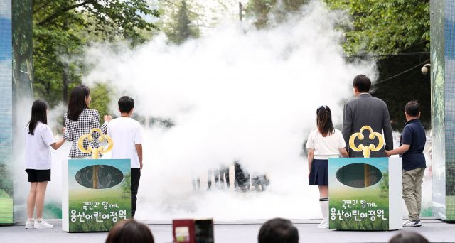 윤석열 대통령과 부인 김건희 여사가 4일 서울 용산 대통령실의 앞마당에 조성된 용산 어린이정원 개방행사에 어린이들과 함께 개문 퍼포먼스를 하고 있다. 대통령실통신사진기자단