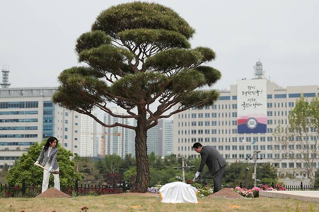 [서울=뉴시스] 윤석열 대통령과 부인 김건희 여사가 4일 서울 용산 대통령실 앞 미군기지 반환부지에 조성된 용산어린이정원 내 전망언덕에서 기념식수를 하고 있다. (사진=대통령실 제공) 2023.05.04. photo@newsis.com *재판매 및 DB 금지