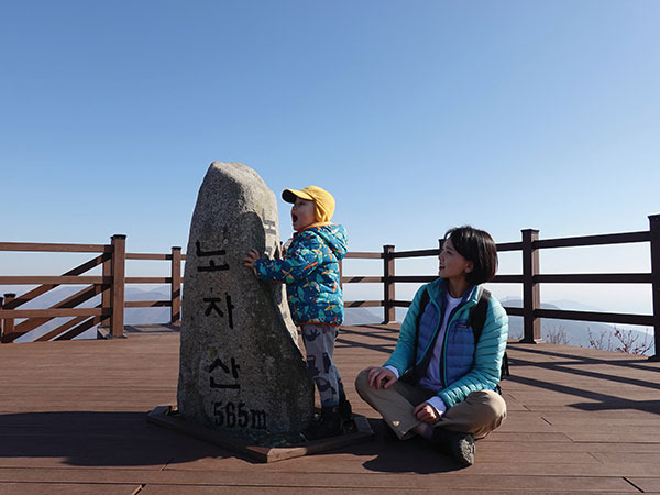 거제 노자산 표지석 앞에서 즐거워하는 김현재군과 엄마 전미은씨.