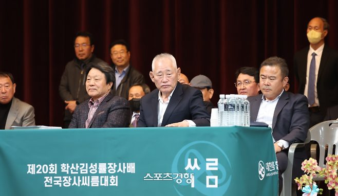 대한씨름협회 황경수 회장(가운데)이 지난 4월  경남 창원시 진해문화센터 체육관에서 열린 제20회 학산 김성률장사배 전국씨름대회 현장을 찾아 관계자들과 경기를 지켜보고 있다. 대한씨름협회 제공