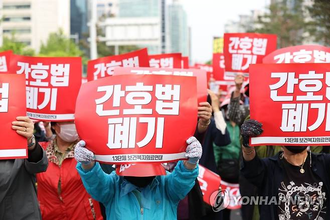 '간호법 폐기' 팻말 들고 (서울=연합뉴스) 김성민 기자 = 대한의사협회를 비롯한 13개 보건복지의료연대 관계자들이 3일 오후 국회 인근에서 열린 '간호법·면허박탈법 강행처리 더불어민주당 규탄대회'에서 팻말을 들고 있다. 2023.5.3 ksm7976@yna.co.kr