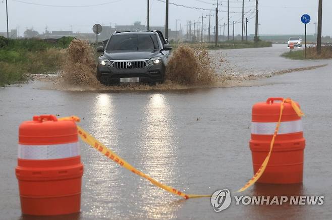 빗물에 잠긴 도로 (서귀포=연합뉴스) 박지호 기자 = 제주도 전역에 폭우가 쏟아진 4일 오후 제주 서귀포시 대정읍 상모리의 해안도로가 침수돼 차량 통행이 일부 통제되고 있다. 2023.5.4 jihopark@yna.co.kr