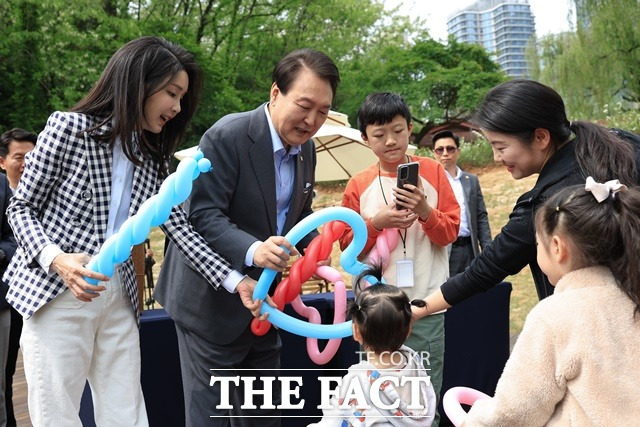 윤석열 대통령의 '용산 시대' 1주년을 맞아 120년 금단의 땅이 용산어린이정원으로 탈바꿈했다. 4일 서울 용산 대통령실 앞 미군기지 반환부지에 조성된 용산어린이정원을 찾은 윤석열 대통령과 김건희 여사가 아이들에게 풍선을 선물하고 있다. /대통령실