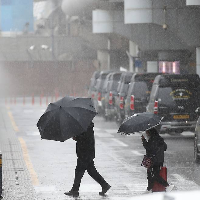 4일 오전 제주국제공항 1층 도착장에 우산을 쓴 관광객들이 발걸음을 재촉하고 있다. /뉴시스