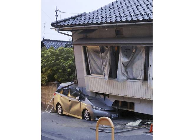 일본 이시카와현 노토반도에서 5일 발생한 규모 6.5의 지진으로 스즈시의 건물이 내려앉아 차가 깔린 모습. /교도통신 연합뉴스