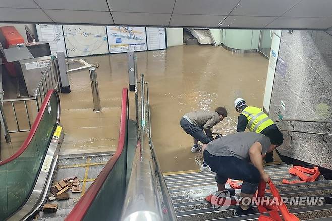 5일 광주 지하철 1호선 공항역 내부가 폭우에 침수돼 광주도시철도공사 관계자가 배수 작업을 하고 있다.[연합]